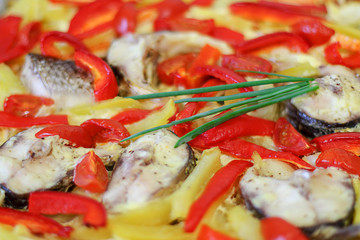 Dietary dish. Baked fish with vegetables and cream sauce: sweet pepper or Bulgarian pepper, tomatoes, onions and spices. Selective focus, close-up.