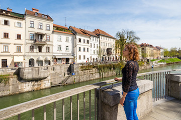 Fototapeta na wymiar Young woman is admiring old buildings and apartments in old part of Ljubljana, Slovenia