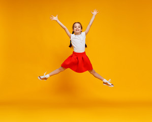 Fototapeta na wymiar funny child girl jumping on colored yellow background.