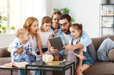 large family mother, father and children with tablet computer at home.