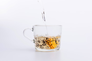 Black tea pouring into glass cup Isolated on white background