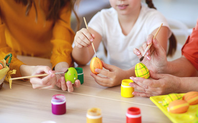 happy Easter! family grandmother, mother and child paint eggs and prepare for holiday.