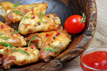 Chicken baked wings on wooden background. chicken wings, ketchup and pepper mix, close-up