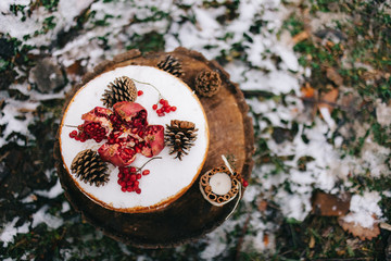 Handmade brown biscui tcake decorated with granate and cone cakes with cream