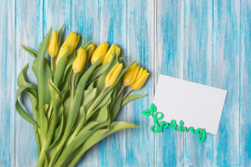 Top view on spring yellow tulips bouquet with mockup of greeting card