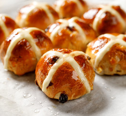 Hot cross buns, freshly baked hot cross buns on white parchment paper, close-up. Traditional easter food - 256537147