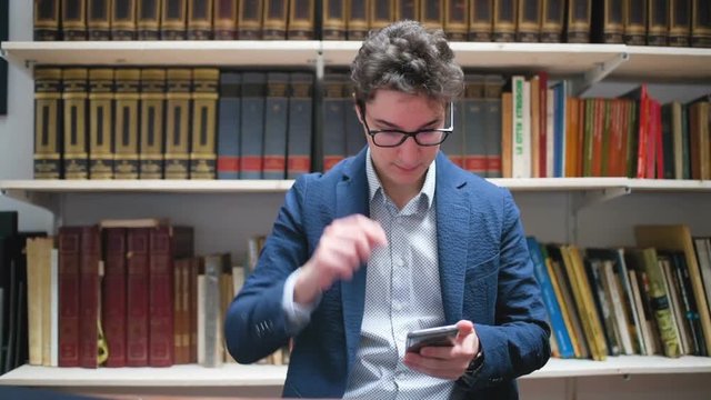 Professional young man in office using smart phone&ndash; apprentice, creative, remote working concept