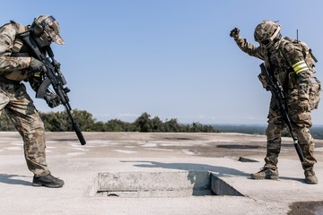Military with sniper rifles storming the building standing on the roof