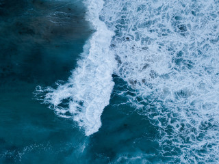 Top down view of wave with white breaking foam.