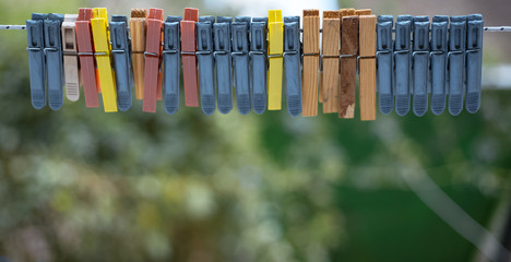 Colorful clothespins outdoor, on the rope over blur background.