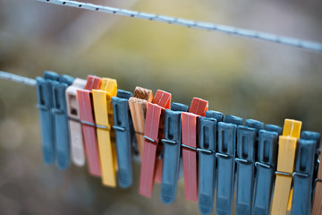 Colorful clothespins outdoor, on the rope over blur background.