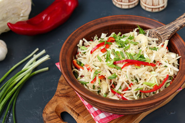 Healthy salad from cabbage and sweet pepper in a brown salad bowl