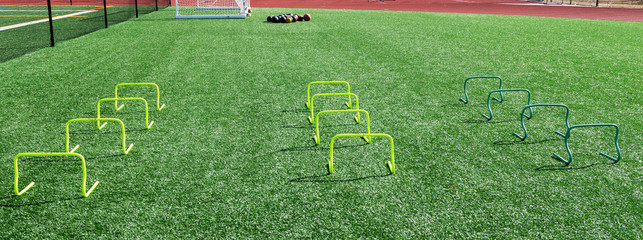 Mini hurdles and medicine balls on turf field