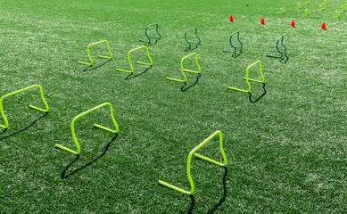 Yellow mini hurdles and orange cones on turf field