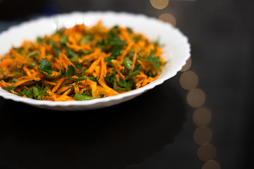 Salad in white plate on black background.
