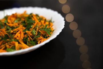 Salad in white plate on black background.