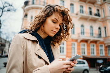 Portrait of young woman wearing beige coat and hoodie