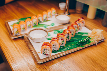 Sushi Smoked Philly plateau buffet in night dining resturant flat lay. Delicious Philadelphia salmon flesh seaweed and ginger. Rolls served on  plate in a restaurant. The norwegian salmon and Fish.