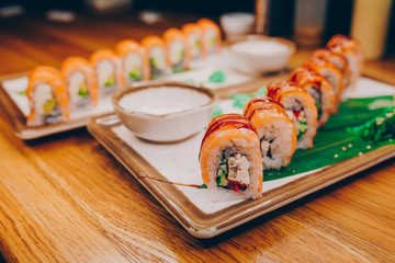 Sushi Smoked Philly plateau buffet in night dining resturant flat lay. Delicious Philadelphia salmon flesh seaweed and ginger. Rolls served on  plate in a restaurant. The norwegian salmon and Fish.