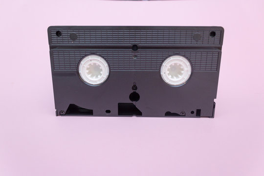 Old VHS videotapes, retro concept. Video cassette on a pink background