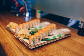 Sushi Smoked Philly plateau buffet in night dining resturant flat lay. Delicious Philadelphia salmon flesh seaweed and ginger. Rolls served on  plate in a restaurant. The norwegian salmon and Fish.