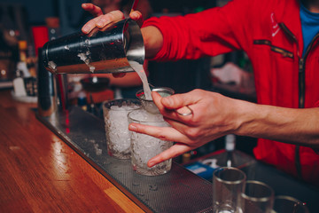 Bartender pouring using strainer Sweet pink healthy Cocktail drink on a bar counter . Bartender view . Trendy stylish white. Copy paste for design people and luxury concept service barman in nightclub