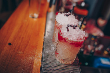 Bartender pouring using strainer Sweet pink healthy Cocktail drink on a bar counter . Bartender view . Trendy stylish white. Copy paste for design people and luxury concept service barman in nightclub