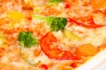 Delicious pizza with broccoli, tomatoes and vegetables, closeup shot