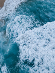 Top down view aerial of waves coming into the coast.