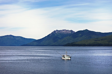 Fishing boat with Alaskan landscape