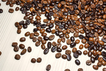 Coffee beans on a light wooden table