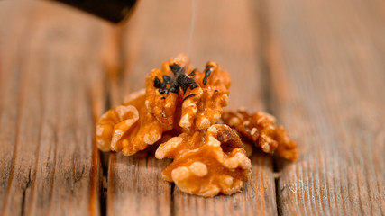 MACRO: Smoke rises from the burnt walnut halves after being roasted by blowtorch