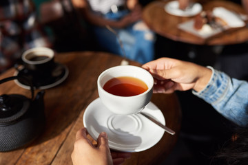 Woman sitting at a cafe table drinking tea
