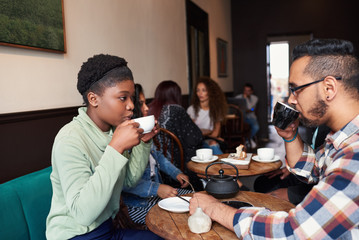 Multiethnic young couple talking over drinks in a cafe