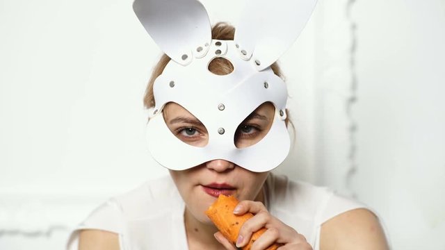 Ready for party. Happy Easter. Pretty, trendy woman is wearing bunny ears. Easter holiday concept. Young woman are preparing for Easter celebration. Bunny girl eat carrot and looks very sensually.