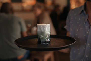 Waiter serving cocktails in a trendy bar at night