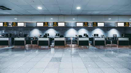 Front view of a check-in area in a modern airport: luggage accept terminals with baggage handling...