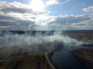 The smoke from the burning of dry grass (drone image).Local residents set fire to the grass specifically. Small animals are bending. Local features and habits. Near Kiev,Ukraine