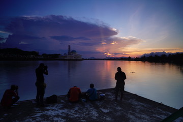 wonderful burning sunset with view silhoutte people at bridge and mosque