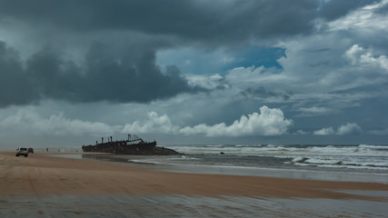 A shipwreck close to shore with stormy skies