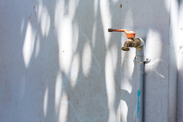 Old rusty tap leaking Faucet Water consumption concept.