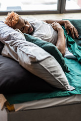 Fototapeta premium Ładny, atrakcyjny mężczyzna leżący w wygodnym łóżku