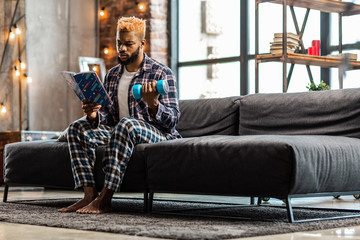 Obraz premium Nice serious man studying a book about sport