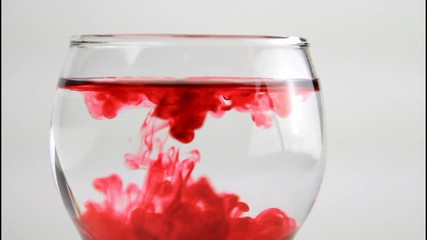 Red water droplet on transparent glass