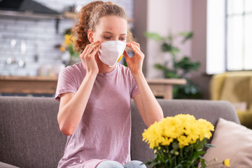 Resolute long-haired woman wearing special mask while suffering