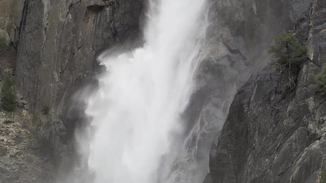 Close up slow motion shot of lower Yosemite falls in early spring, snow melt runoff creating large waterfall and mist