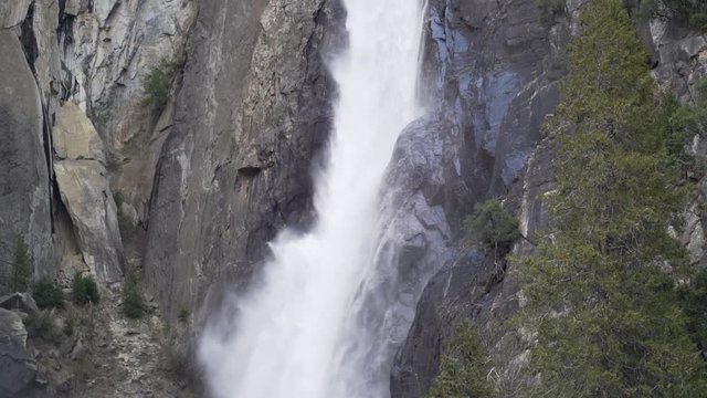Slow motion pan up shot of lower Yosemite falls in early spring