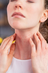 Disturb young woman closing her eyes and scratching neck