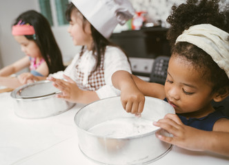 Group of kids are preparing the bakery in the kitchen .Children learning to cooking cookies