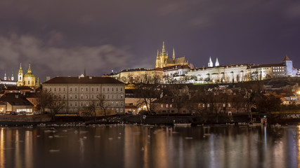 night image of Prague castle with river in the foreground